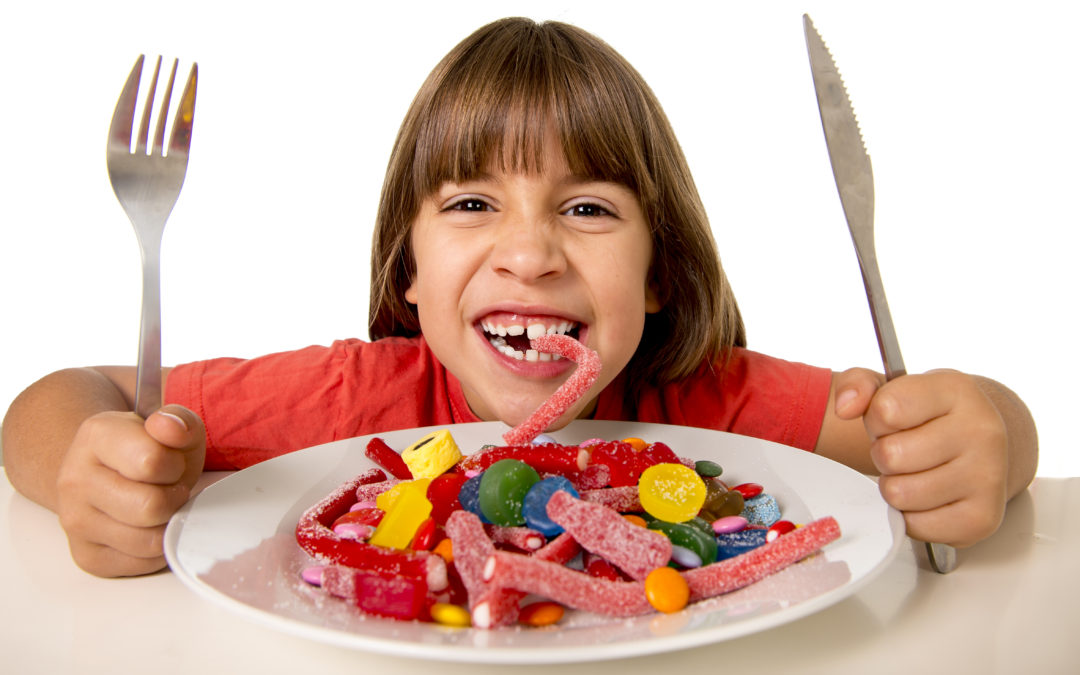 child eating candy like crazy in sugar abuse and unhealthy sweet nutrition concept